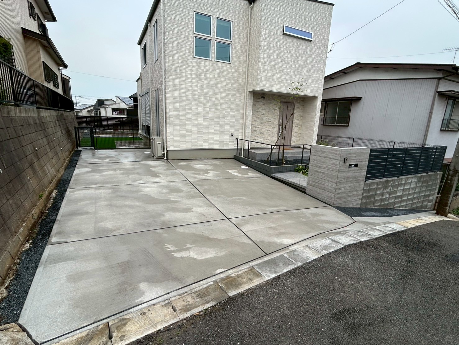 前面道路が傾斜になっているため、敷地に入る導線と敷地内はなるべくフラットアプローチになるようにプランを考えました。
門塀はデザイン性と土留めとして機能し、家への導線を駐車場側から併用する事により高低差を感じないお庭になりました。